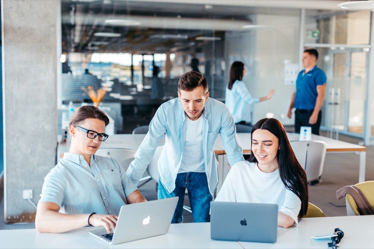 A team collaborating over laptops in an office